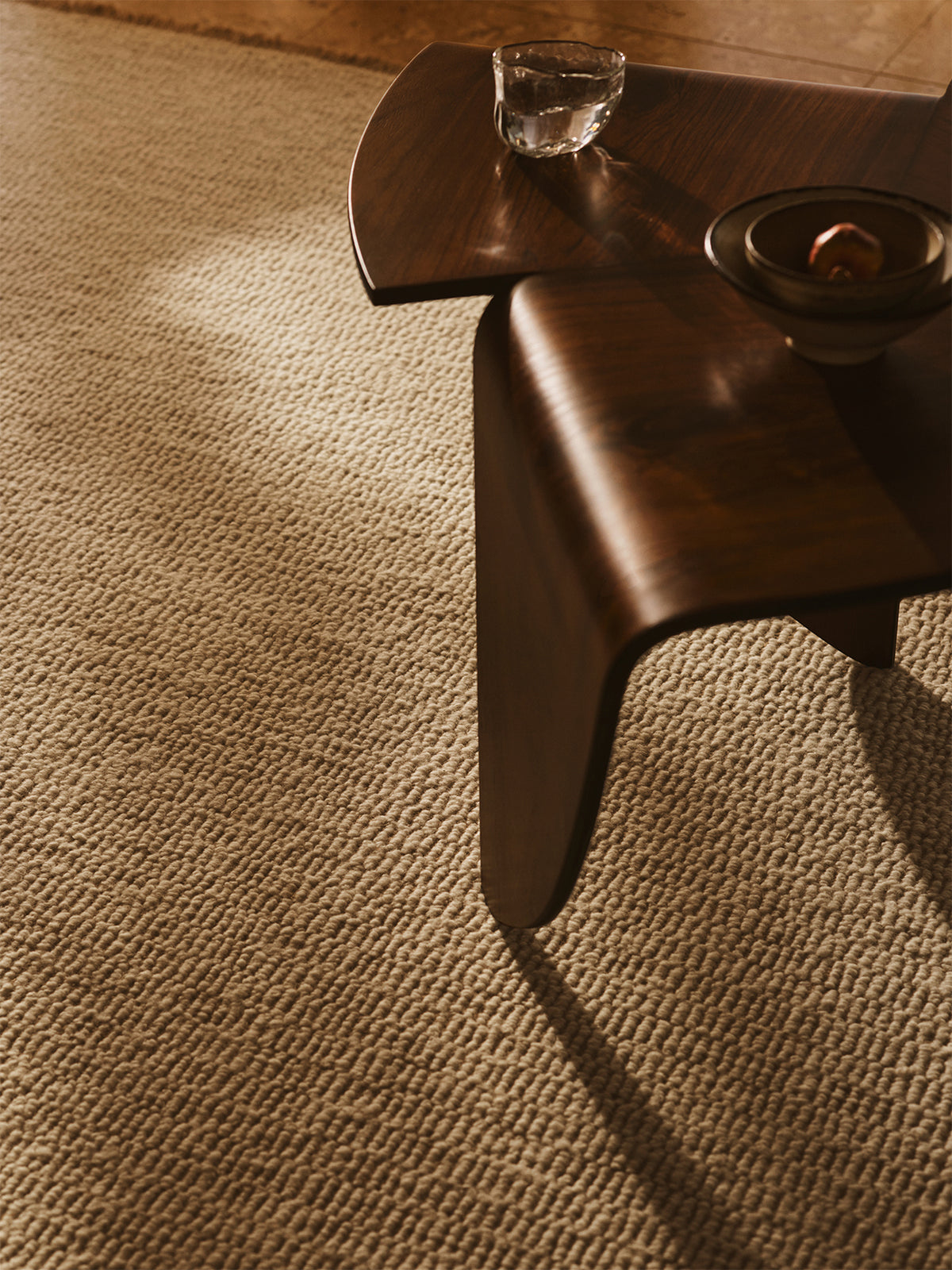 Wooden chair leg on a textured brown carpet | Armadillo Abbey Rug