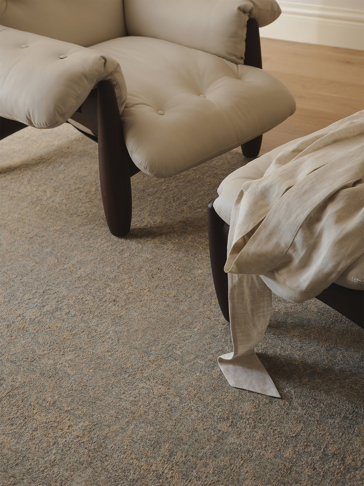Beige armchair and ottoman on a carpeted floor with a light-coloured blanket | Armadillo Adagio Rug