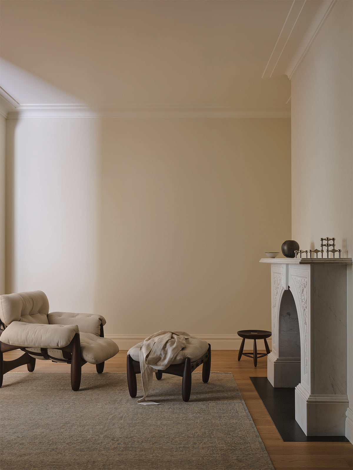 Living room with a fireplace, armchair, and ottoman | Armadillo Adagio Rug